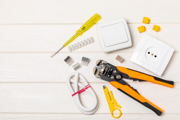 Electrician equipment on a wooden background with copy space.Top view.Electrician tool set.Multimeter, tester,screwdrivers,cutters,duct tape,lamps,tape measure and wires.Flet lay.Concept building © Avocado_studio
