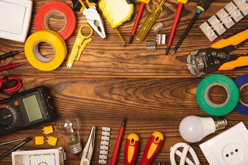 Electrician equipment on a wooden background with copy space.Top view.Electrician tool set.Multimeter, tester,screwdrivers,cutters,duct tape,lamps,tape measure and wires.Flet lay.Concept building © Avocado_studio