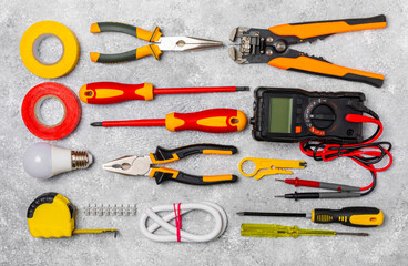 Electrician equipment on marble background with copy space.Top view.Electrician tool set.Multimeter, tester,screwdrivers,cutters,duct tape,lamps,tape measure and wires.Flet lay. Construction concept. © Avocado_studio