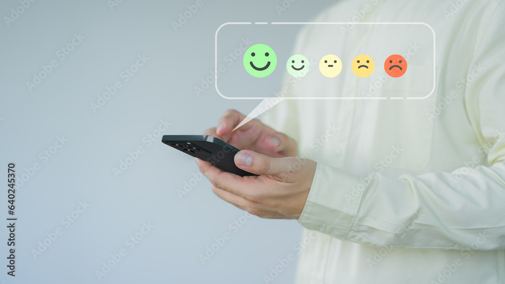 Poster Client hands using a mobile phone with pop up smile face icon for feedback review satisfaction service opinion and testimonial. Customer service experience assessment and business satisfaction survey.