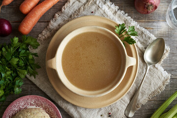 A soup plate of chicken bone broth on a table