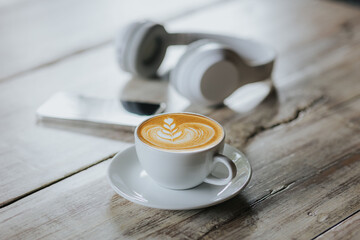 Cup of hot latte on wooden table in cafe shop.