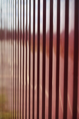 Metal red iron fence abstract  background, texture with diminishing perspective