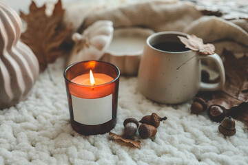 Obraz na płótnie Canvas Burning candle with label isolated in autumn interior