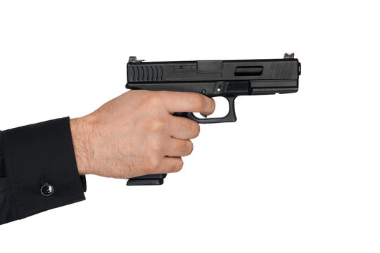 Close up of short-barrelled handgun, typical firearm, held by male's hand. Crop view of man in black shirt, holding black pistol, ready to pull trigger, isolated on white. Concept of weapon, aiming.