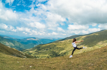 A beautiful young woman runs in a spectacular mountain landscape. The desire to fly, to be free. 