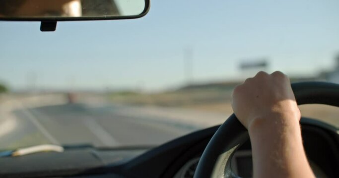 Close-up of female hands on the steering wheel driving a car. High quality 4k footage
