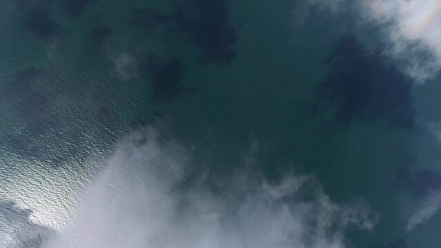 vertiakle Luftbildaufnahme von einer Yacht auf der Ostsee über den Wolken 