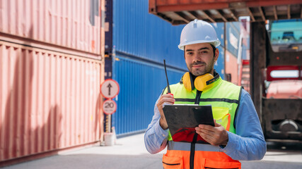 Foreman checking inventory or task details at Container cargo harbor. Logistics concept inside the...
