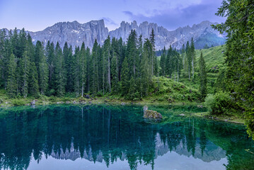 Fototapeta na wymiar Tranquil Lago di Carezza during cloudy summer twilight in the Italian Dolomites