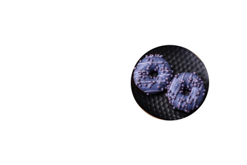 Delicious sweet donut of purple color in glaze and with lilac balls