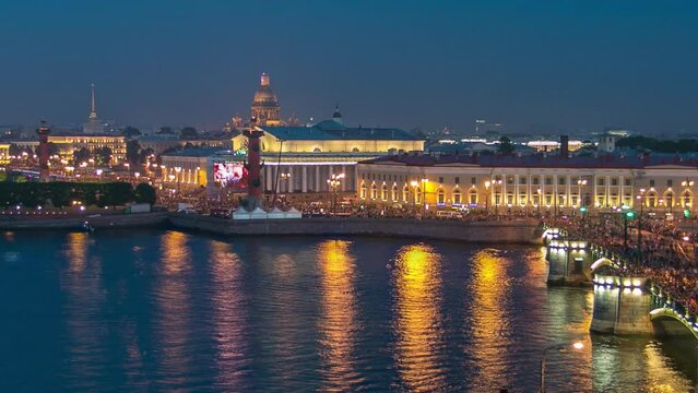 Timelapse of night aerial view: Vasilyevsky Island Spit, Birzhevoy Bridge, and Rostral Column seen from a rooftop in Saint Petersburg, Russia. Illuminated historical buildings