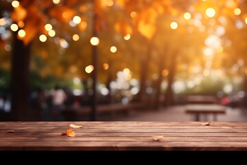 Empty wooden table with leaves and bokeh lights blurred outdoor cafe background. High quality photo