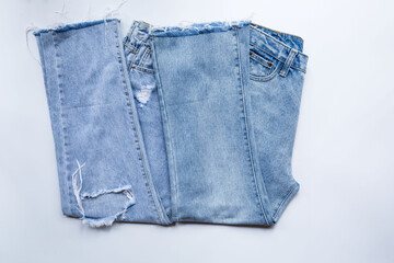 Top view, two jeans trouser on a white background show  torn denim in store and supermarket.concept fashion dress jeans..