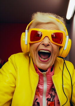 A funny and smiling elderly fashionable woman listen the music with headphone and have fun