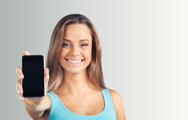 Beautiful young woman holding blank screen smartphone