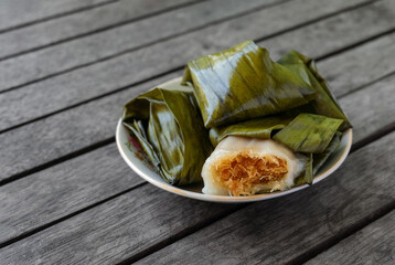 Koci-Koci or kue koci is a traditional cake from Indonesia, made from rice flour, and sugar-filled with grated coconut mixed with palm sugar. Served on a white plate. Selected focus