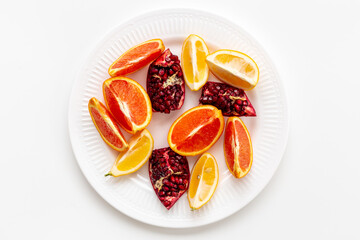 Many mixed fruits on white plate, top view