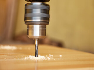 Drill a hole in the board with a drill. Carpentry works. A tool for working with wood.