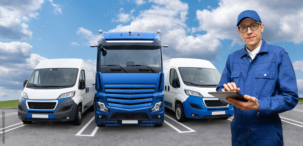 Aufkleber manager with a digital tablet stands next to trucks and vans. fleet management