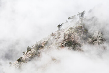 Rocky mountain slope in clouds in Corse, France