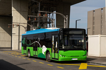 Electric bus at a stop is charged by pantograph. Clean mobility - obrazy, fototapety, plakaty