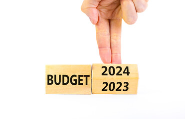 Planning 2024 budget new year symbol. Businessman turns a wooden cube and changes words Budget 2023 to Budget 2024. Beautiful white background, copy space. Business 2024 budget new year concept.