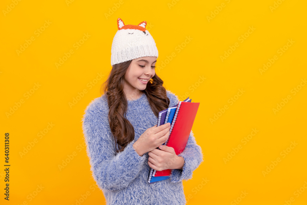 Poster happy kid long hair in hat hold copybook on yellow background, homework