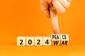 2024 war or peace symbol. Businessman turns a wooden cube and changes words 2024 War to 2024 Peace. Beautiful orange table orange background, copy space. Business 2024 war or peace concept.