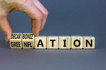 Decarbonization or greenflation symbol. Concept words Decarbonization Greenflation on cubes. Beautiful grey background. Businessman hand. Business decarbonization greenflation concept. Copy space.