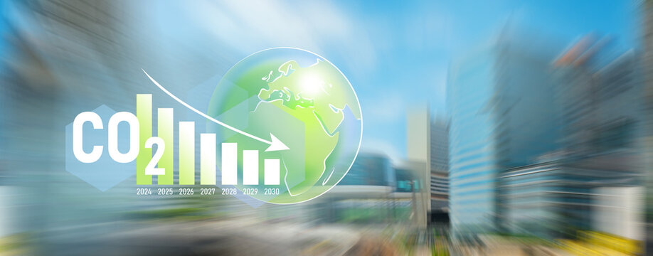 Carbon dioxide emission graph trending downwards. Motion blur of urban city, copy space on right side.
