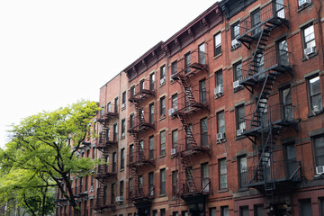 Row of Old Red Brick Apartment Buildings with Fire Escapes in Hell's Kitchen of New York City