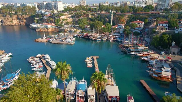 In this aerial stock video, the timeless beauty of the Old Port of Antalya comes to life. The camera soars above the historic harbor nestled within the old town of Antalya, Turkey. The scene showcases