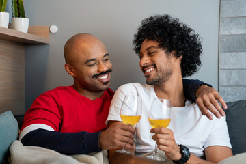 Fototapeta na wymiar Brazilian couple toasting with wine in living room at home