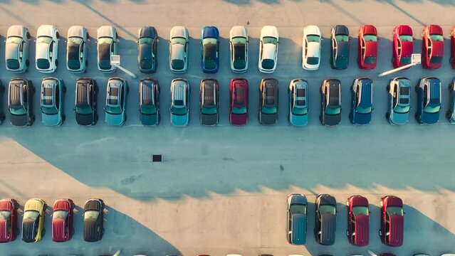 Aerial view of dealership parking lot with many brand new cars for sale. Development of american automotive industry concept