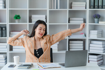 Cheerful business lady working on laptop in office, Asian happy beautiful businesswoman in formal suit work in workplace. Attractive female employee office worker smile.