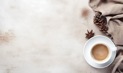 Top view of a coffee in a white cup with dark brown star anise on a saucer against a textured light beige background.