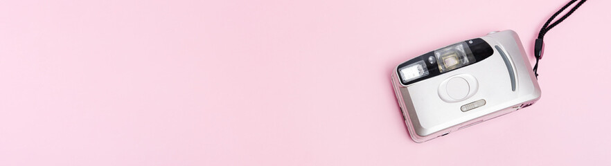 silver film camera banner on pink background top view