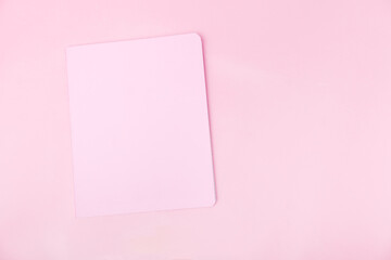 Top view photo workplace with a pink notebook, on an isolated pink background, copy space. female business concept