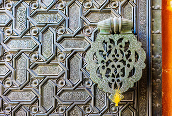 Bronze doors of the Puerta del Perdon gate, adorned with interlacing patterns and geometric designs. North side of the Seville Cathedral. Seville, Andalusia, Spain.