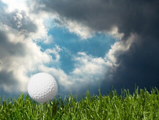 Golf white ball on tee on green grass
