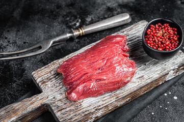 Raw Venison dear steak ready for cooking. Black background. Top view