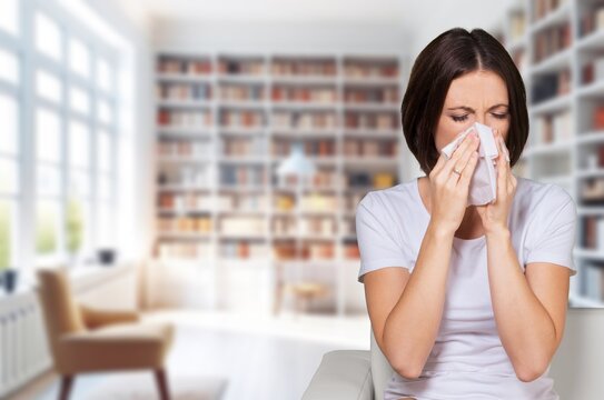 An attack of allergies, woman on the sofa coughing, AI generated image