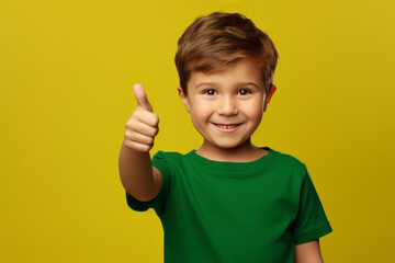 Little boy wearing green t-shirt showing thumbs up and smiling isolated on yellow background.generative ai
