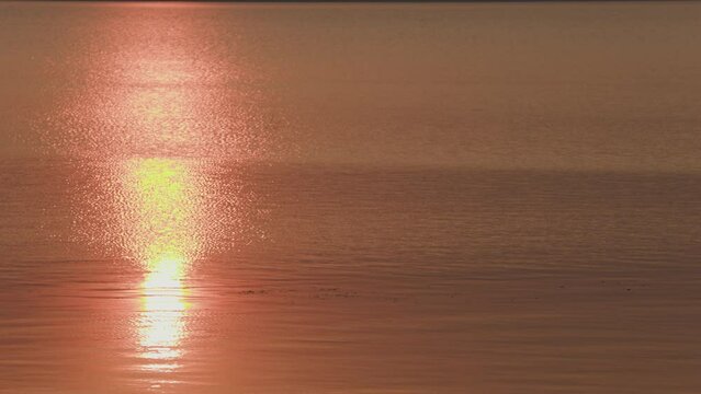 closeup of sunset reflection on a calm lake