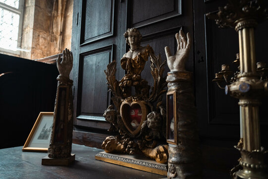 Old decorated relic holders. Sacred objects inside an old sacristy. Religious life and cult of sacred relics. Catholicism, monastic life and faith. Classic style with effigies of cherubs.