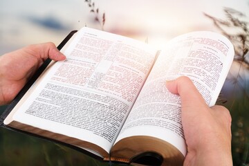 hand of young male prayer reading bible