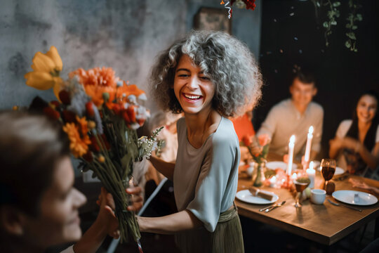 A young woman warmly welcomes guests to her dinner party, embodying candid hospitality. The atmosphere is filled with social celebration as friends gather to enjoy a special evening.
