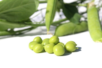 Green Peas pod and peas lie on a white isolated background.	