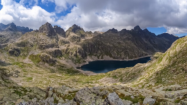 Panoramic view of glacier lake Lac du Basto in the Mercantour National Park in the Valley of Marvels near Tende, Provence-Alpes-C&ocirc;te d'Azur Alpes-Maritimes, France. High mountain ridges in French Alps